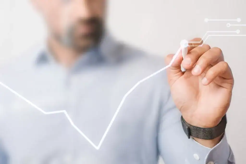 Line 1: Modern businessman drawing an upward trending growth chart with a digital marker, symbolizing business success and analytics.