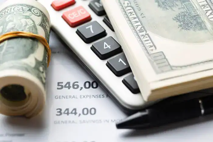 batasnilaipajaknatura  BEST Software Indonesia  Powered by ProInt Rolled US dollar bills calculator receipts and pen on financial documents representing accounting or financial management