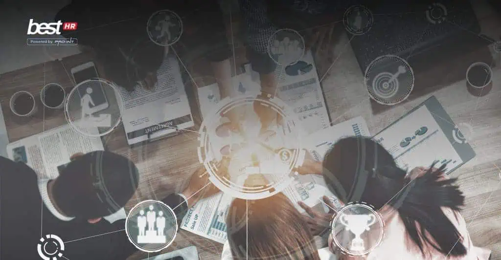 PeranSistemHRIS BEST Software Indonesia Powered by ProInt Advanced business team collaborating with digital interfaces for project management and data analysis at a workspace in Indonesia