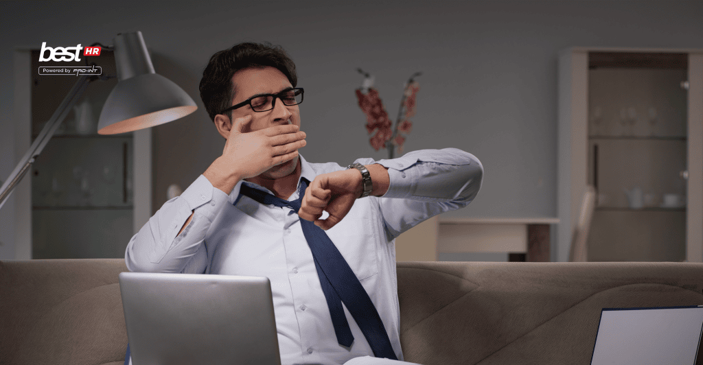 Businessman checking time on his watch while working remotely illustrating challenges of hybrid and WFH work systems